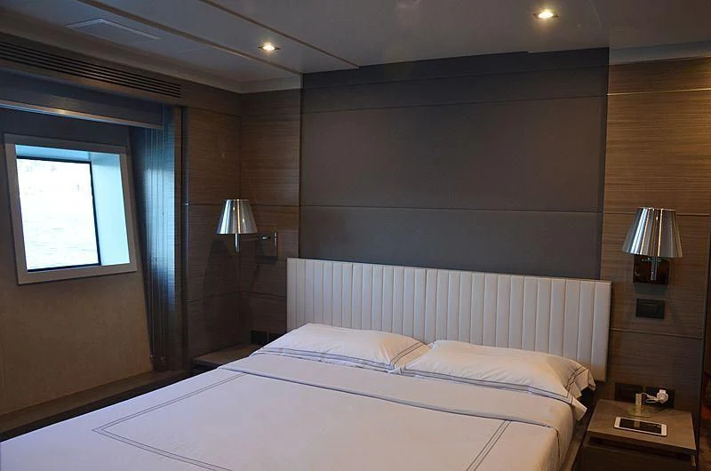 a bedroom with a bed and a lamp aboard CHARISMA Yacht for Sale