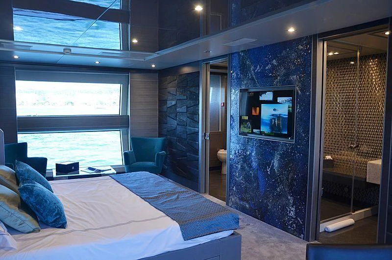 a bedroom with a bed and a fireplace aboard CHARISMA Yacht for Sale
