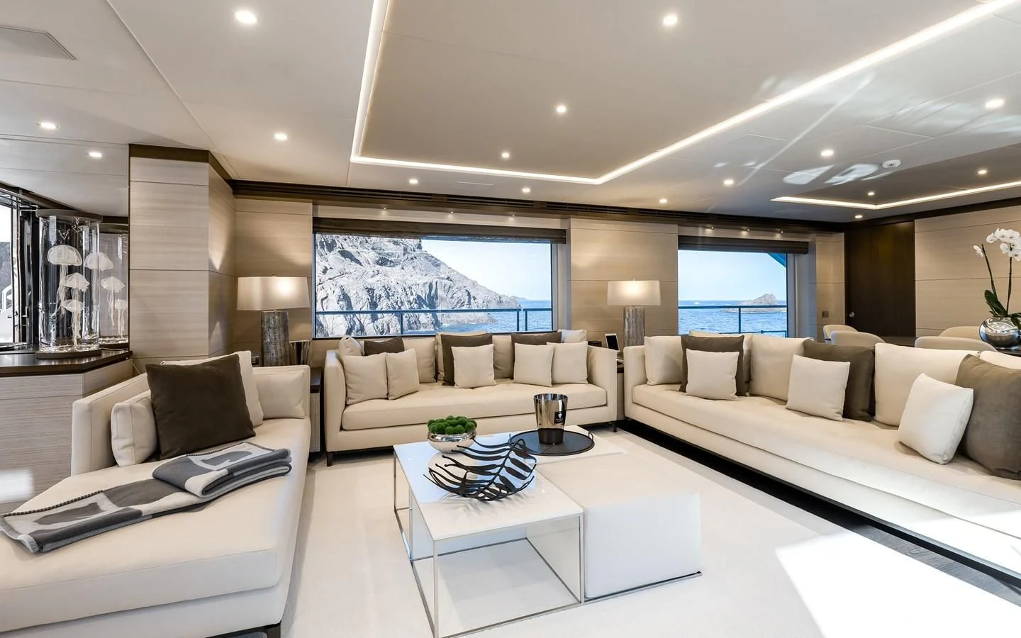 a living room with a large white sofa and a large window aboard CALYPSO Yacht for Charter