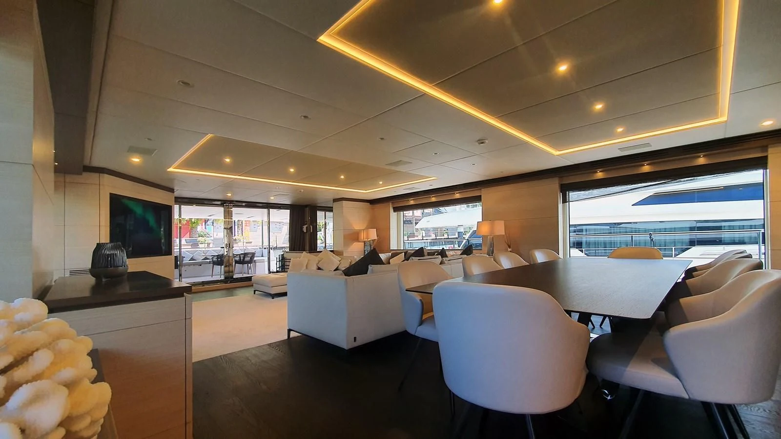 a room with a large window and a table with chairs and a tv aboard CALYPSO Yacht for Charter
