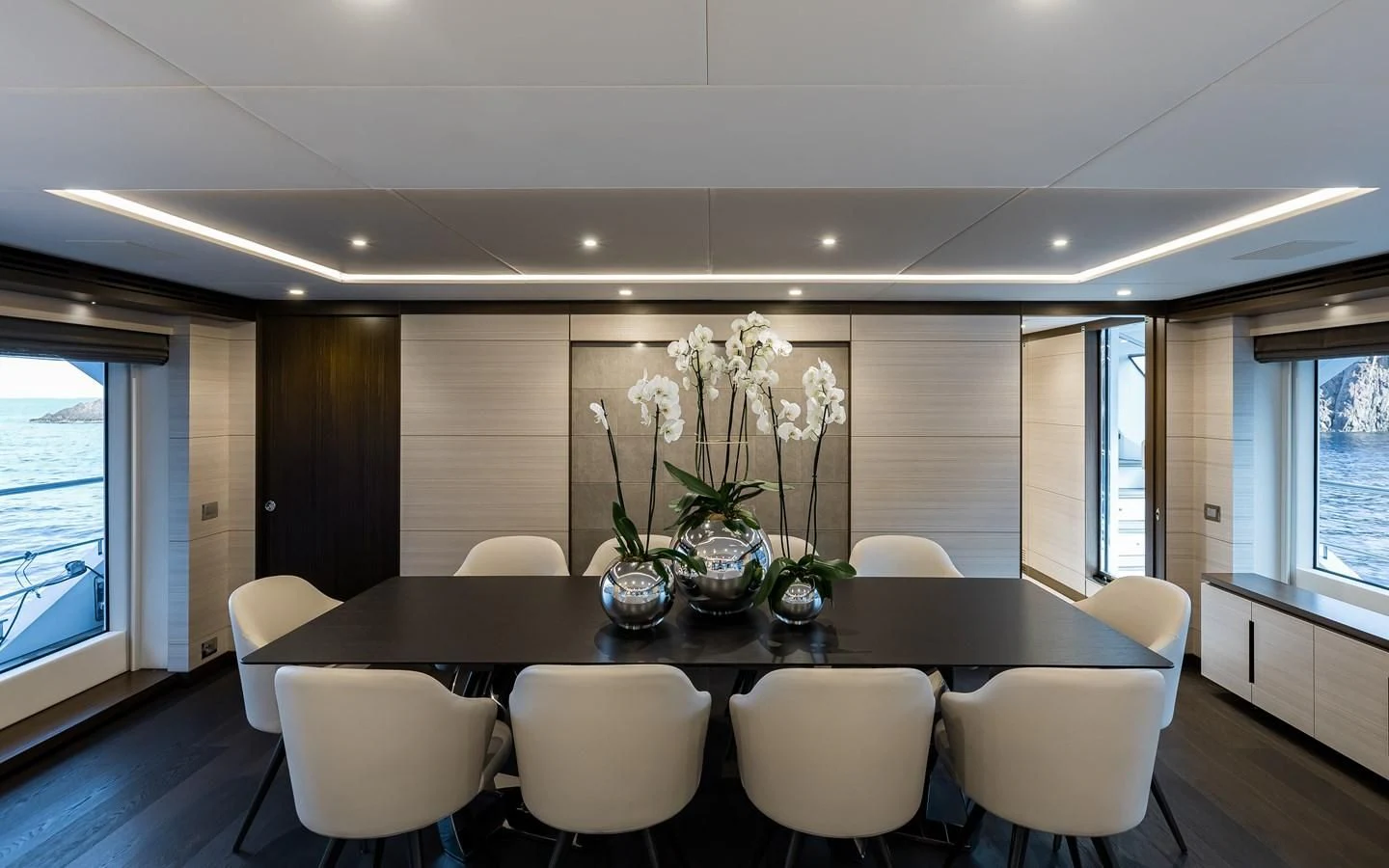 a large dining table with white chairs aboard CALYPSO Yacht for Charter