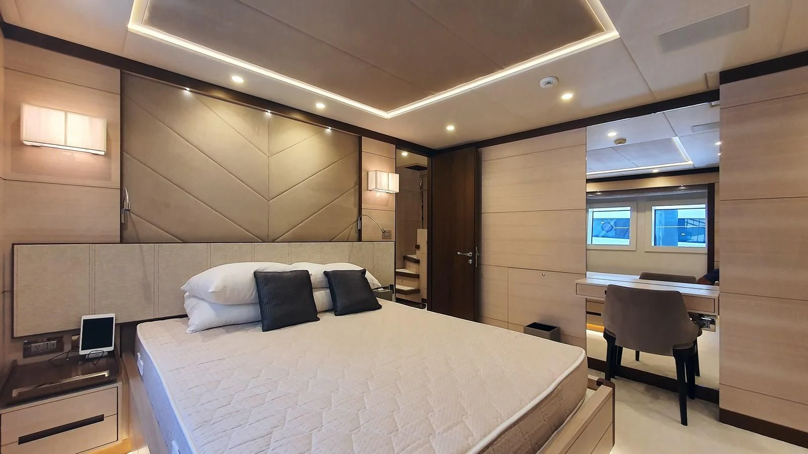 a room with a bed and desk aboard CALYPSO Yacht for Charter