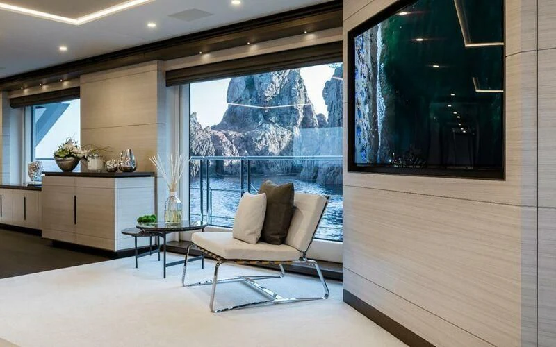 a room with a chair and a table and a window aboard CALYPSO Yacht for Charter