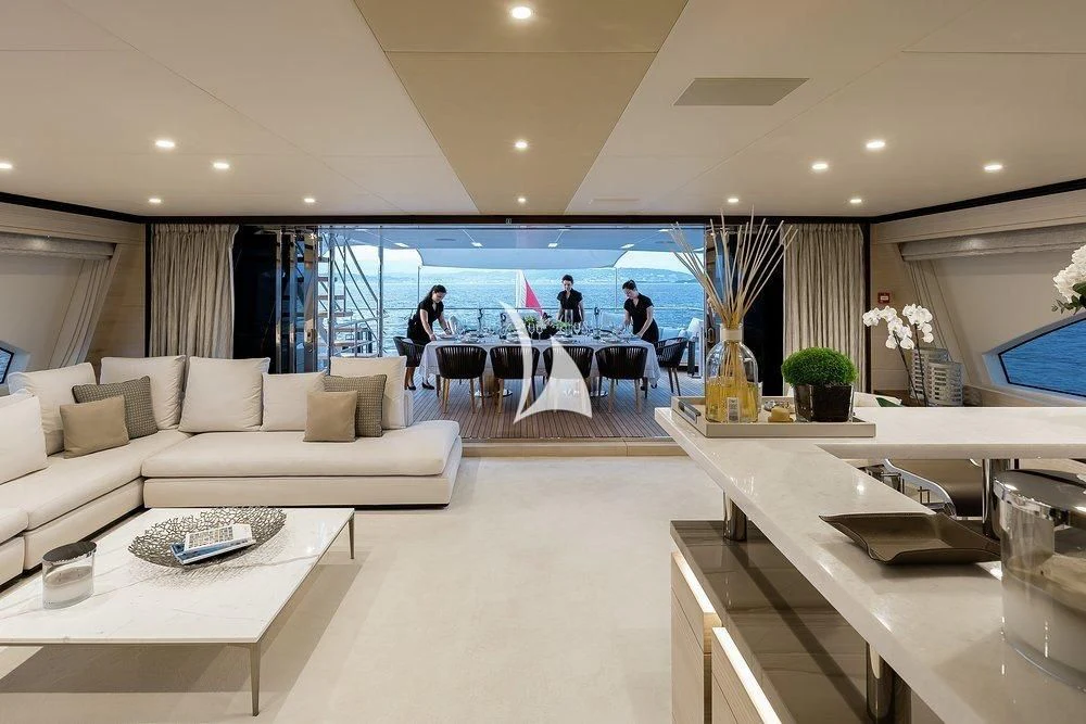 a room with a couch and a table with people sitting at it aboard CALYPSO Yacht for Charter