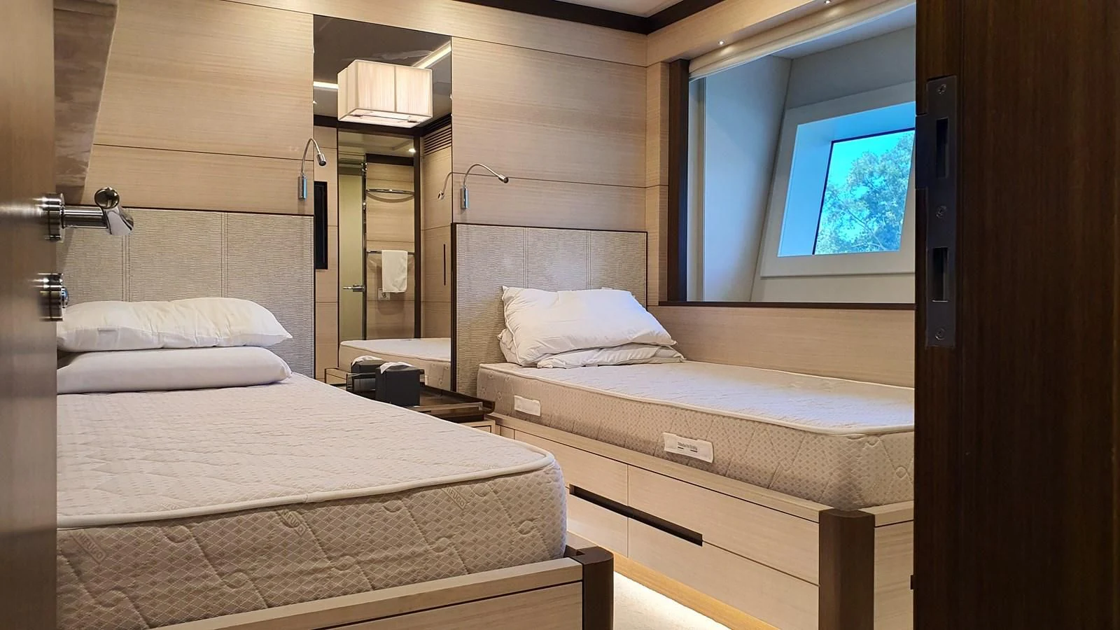 a room with beds and a window aboard CALYPSO Yacht for Charter