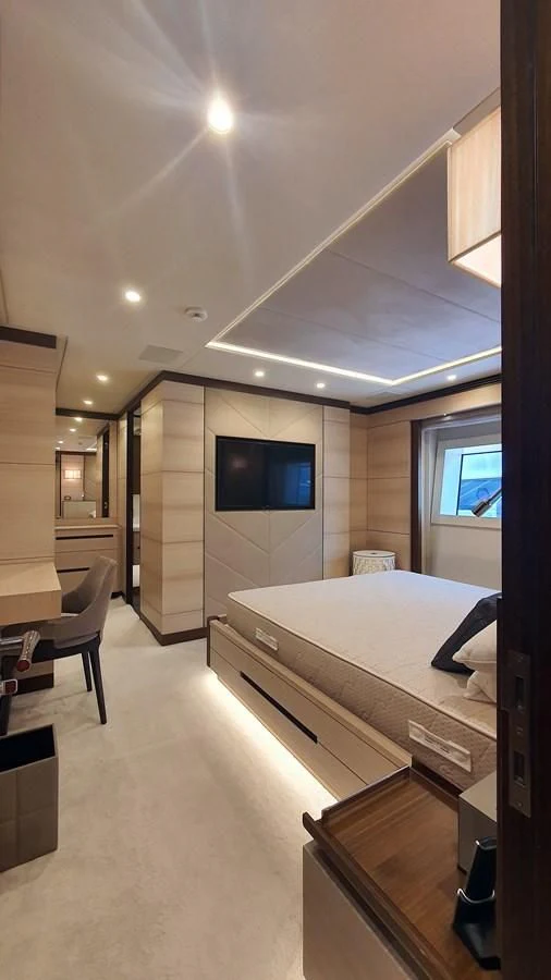 a bedroom with a bed and a tv aboard CALYPSO Yacht for Charter