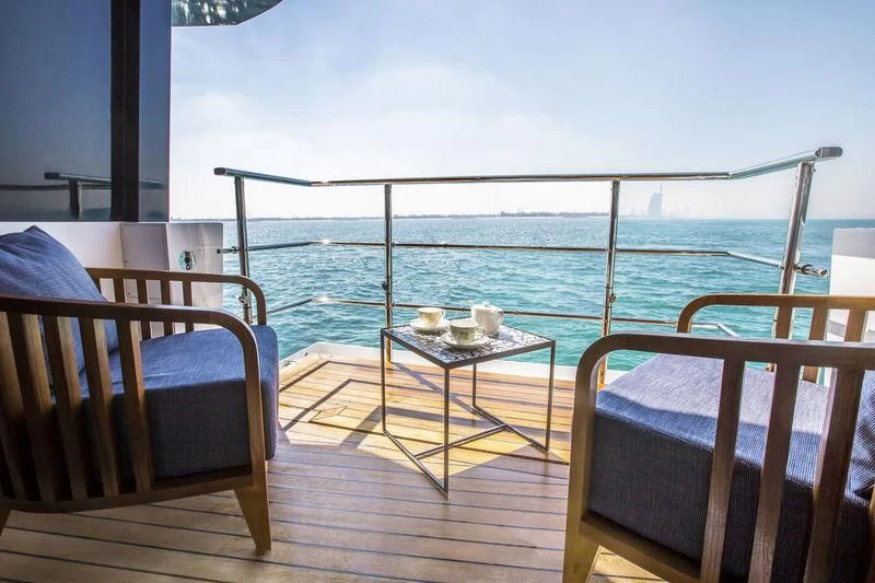 a balcony with a table and chairs aboard C'EST LA VIE Yacht for Sale