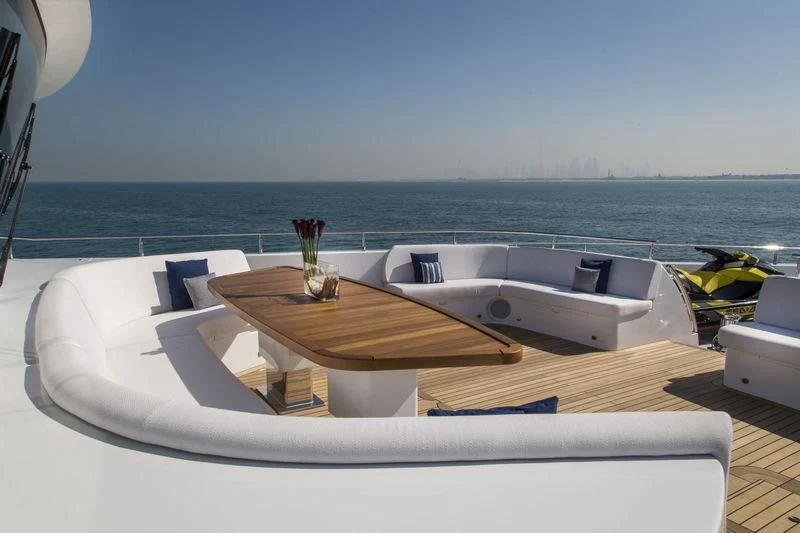 a table with chairs on it next to a body of water aboard C'EST LA VIE Yacht for Sale