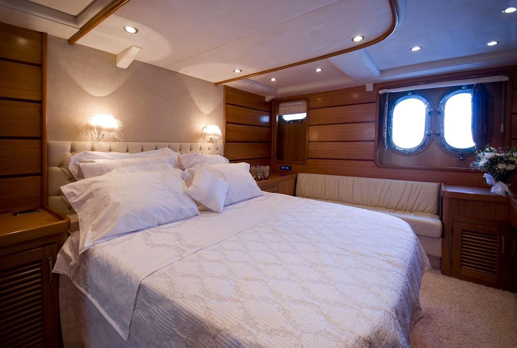 a large bed with white sheets aboard AZMIM Yacht for Sale