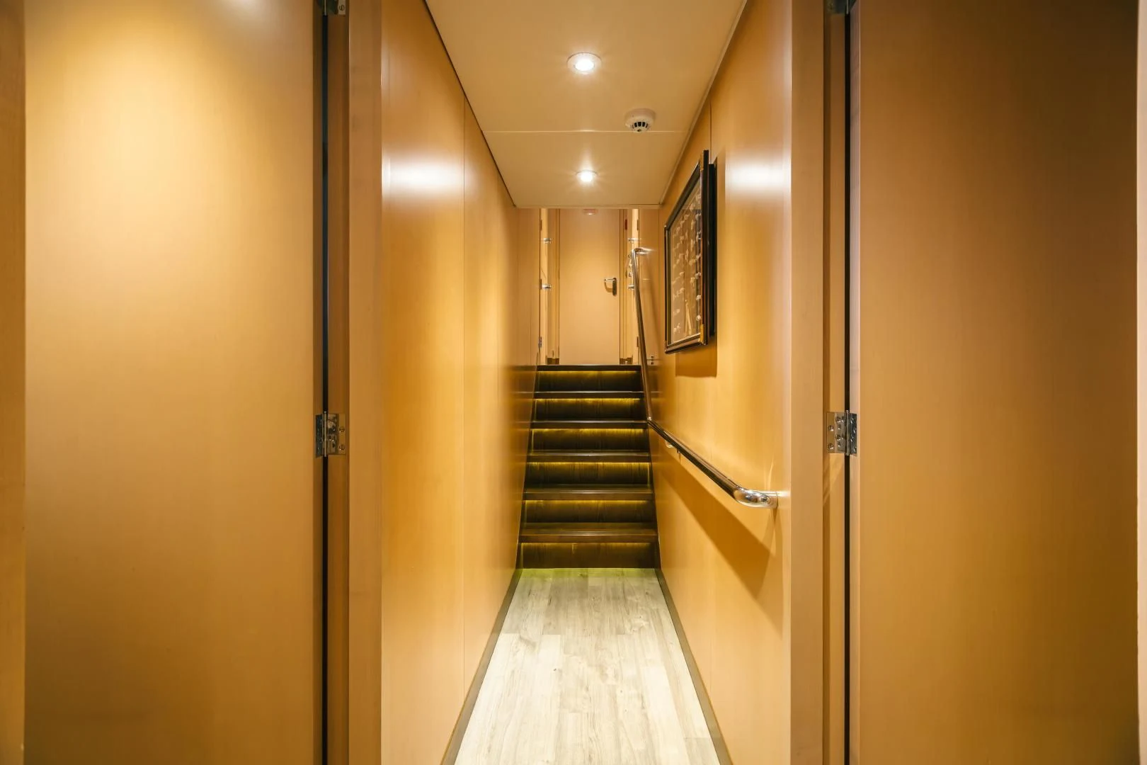 a hallway with a door and a staircase aboard ACTA Yacht for Charter