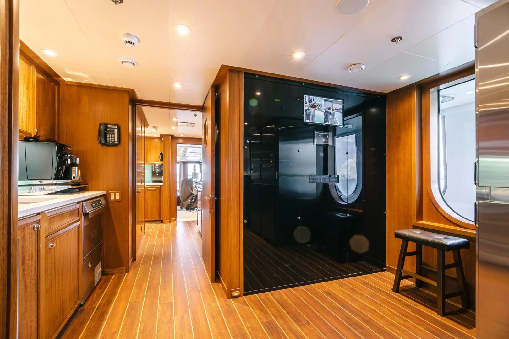 a large kitchen with a black door aboard ACTA Yacht for Charter
