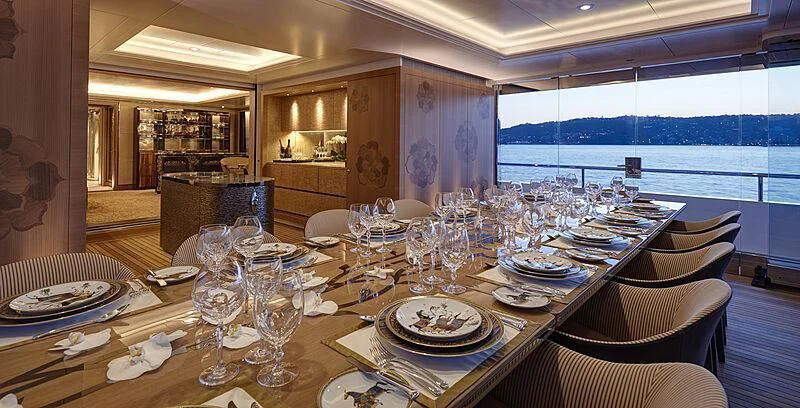 a dining room table set for a dinner party aboard JOY Yacht for Sale