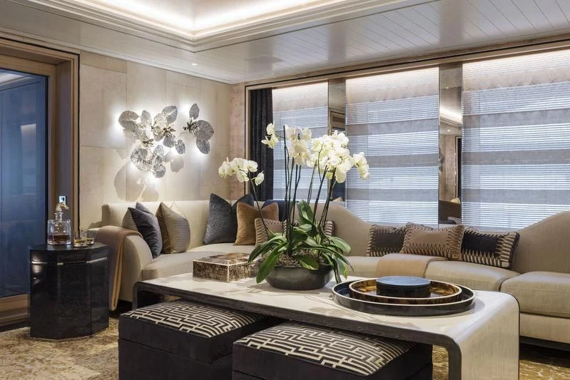 a living room with a couch and a table with flowers aboard JOY Yacht for Sale