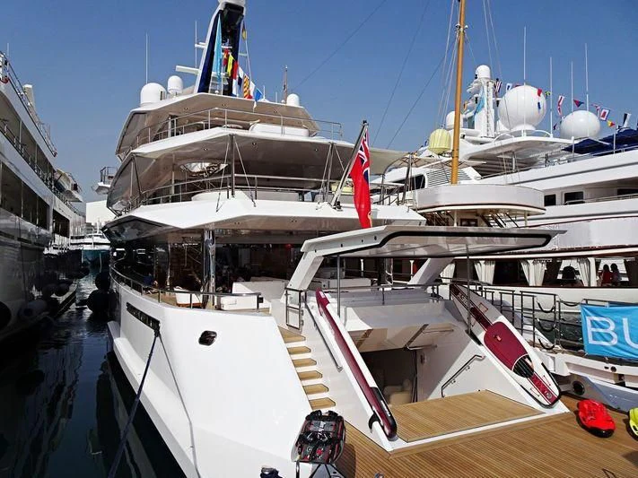 a large white boat with a red flag on it aboard JOY Yacht for Sale