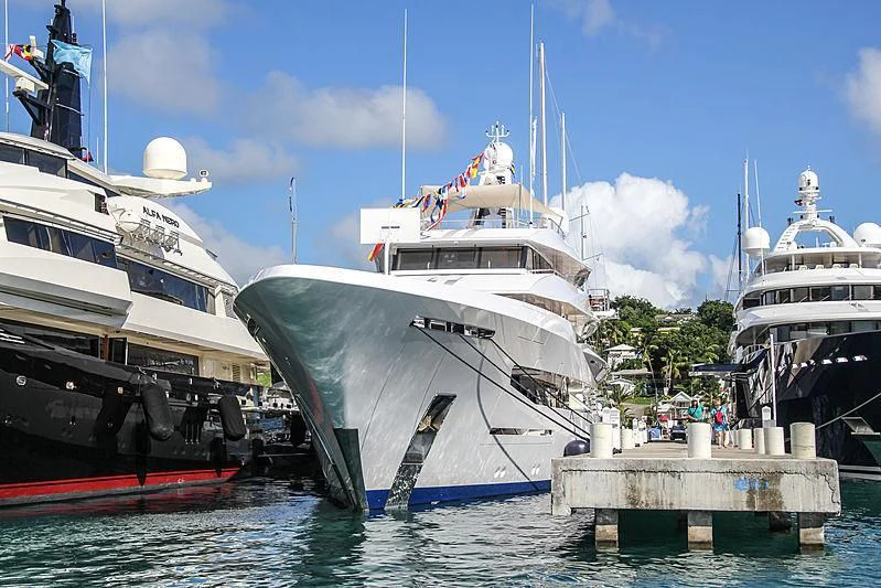 a few large boats are parked at a dock aboard JOY Yacht for Sale