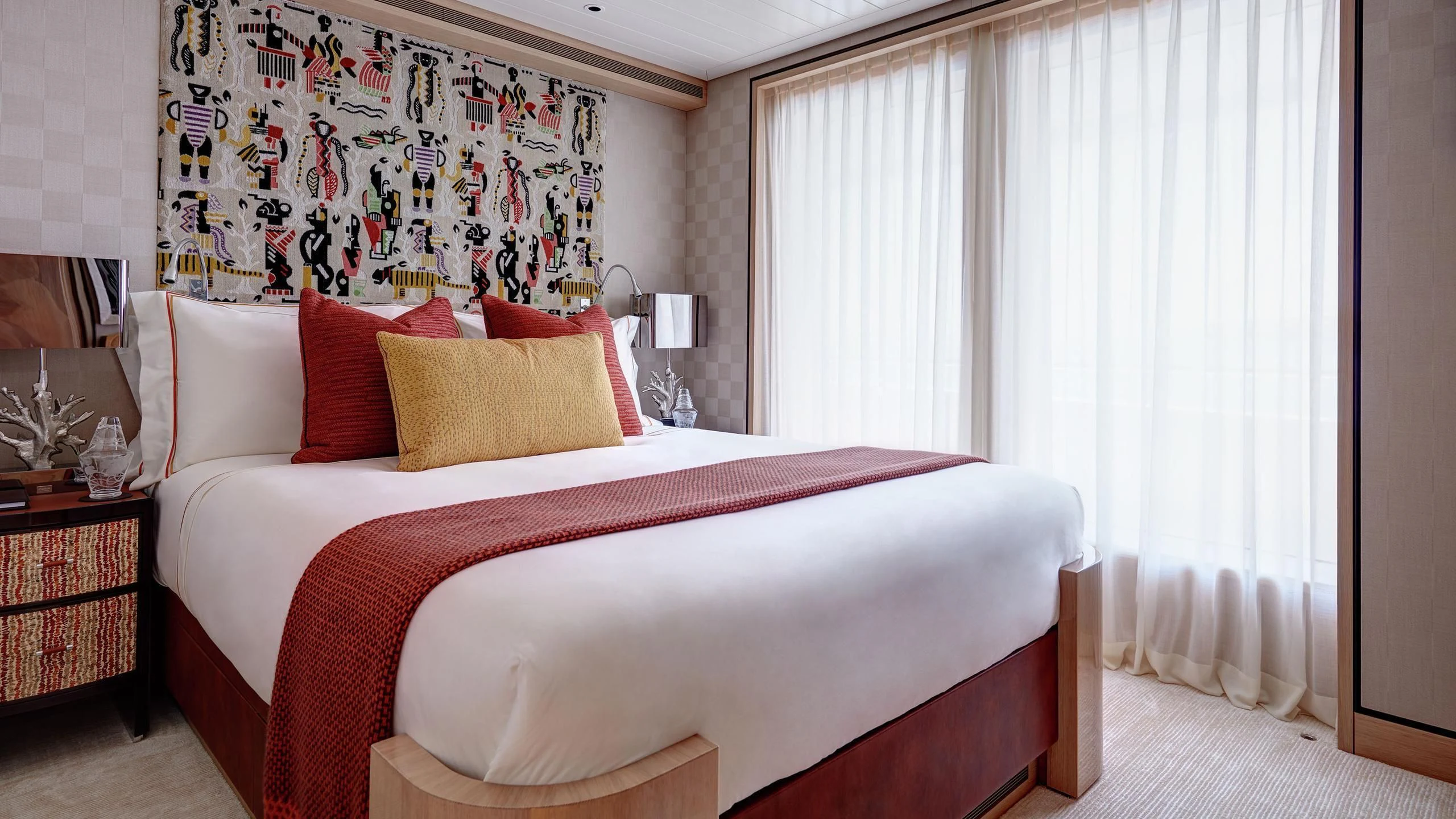 a bed with a red and white bed spread aboard JOY Yacht for Sale