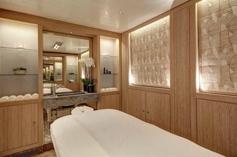 a room with a bed and a mirror aboard JOY Yacht for Sale