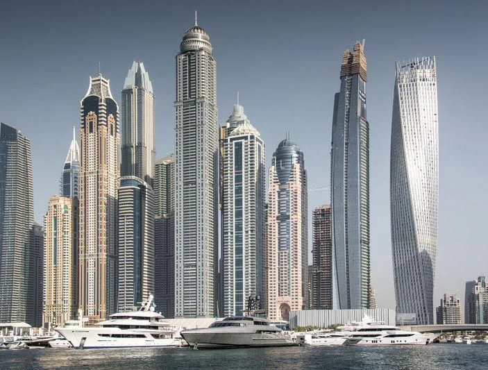Princess Tower skyline with a boat and a boat in the water aboard JOY Yacht for Sale
