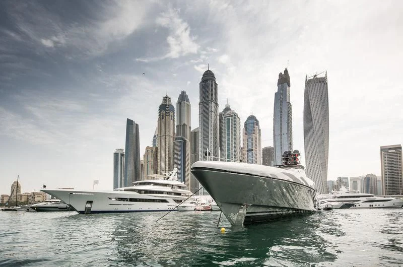 a boat in the water with a city in the background aboard JOY Yacht for Sale