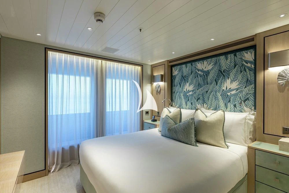 a bed with a blue sheet aboard JOY Yacht for Sale