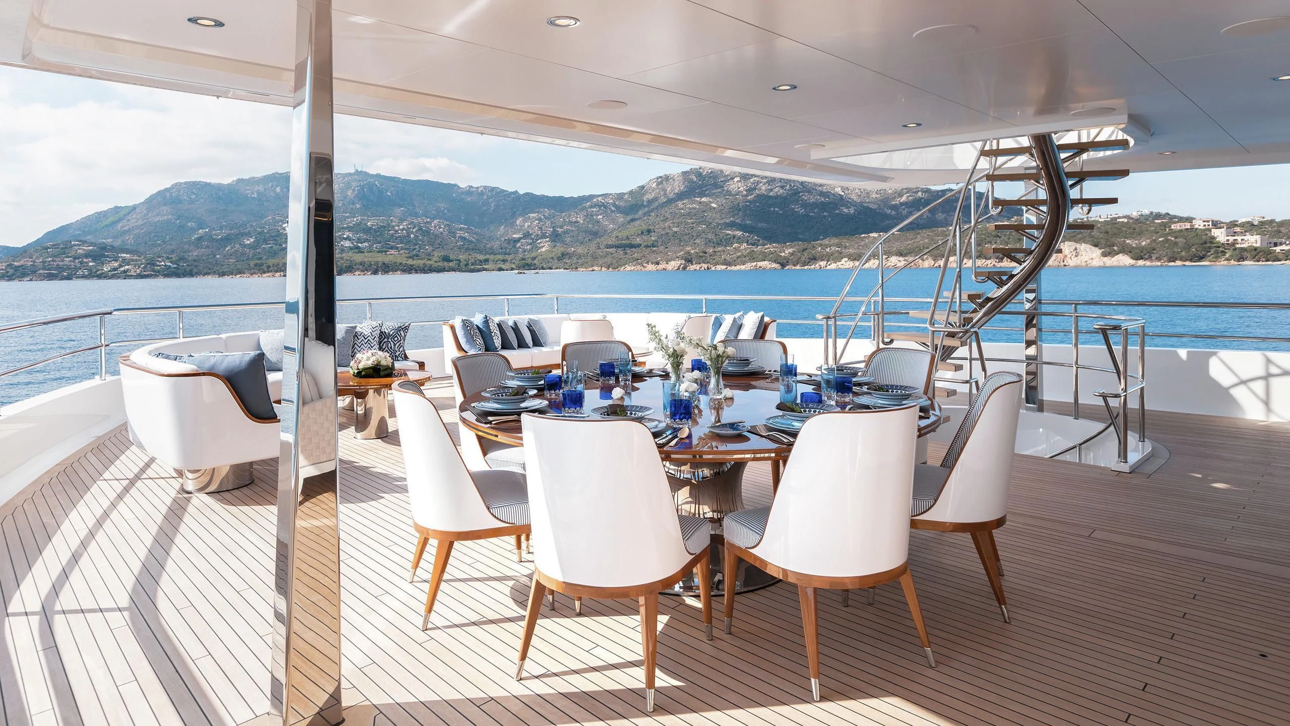 a table set for a meal on a deck overlooking the ocean aboard JOY Yacht for Sale