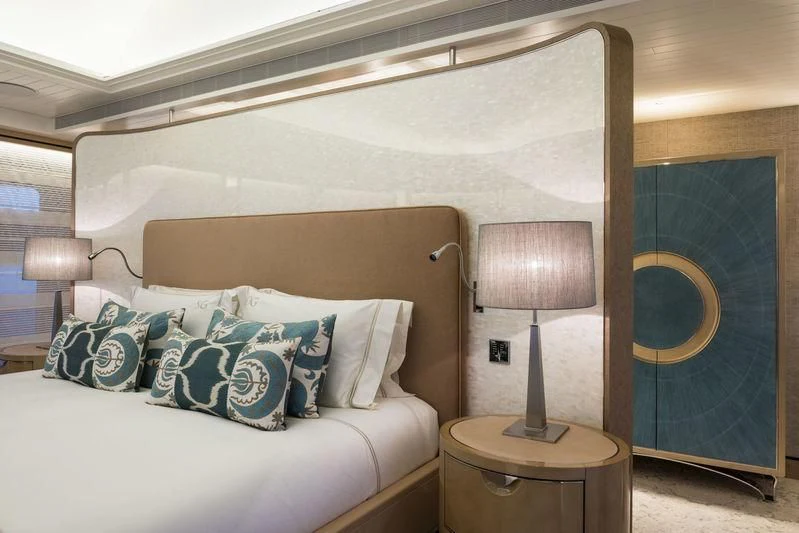 a bed with a painting on the wall aboard JOY Yacht for Sale