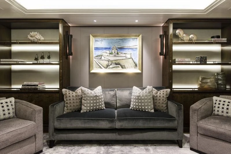 a living room with a couch and a shelf with books aboard JOY Yacht for Sale