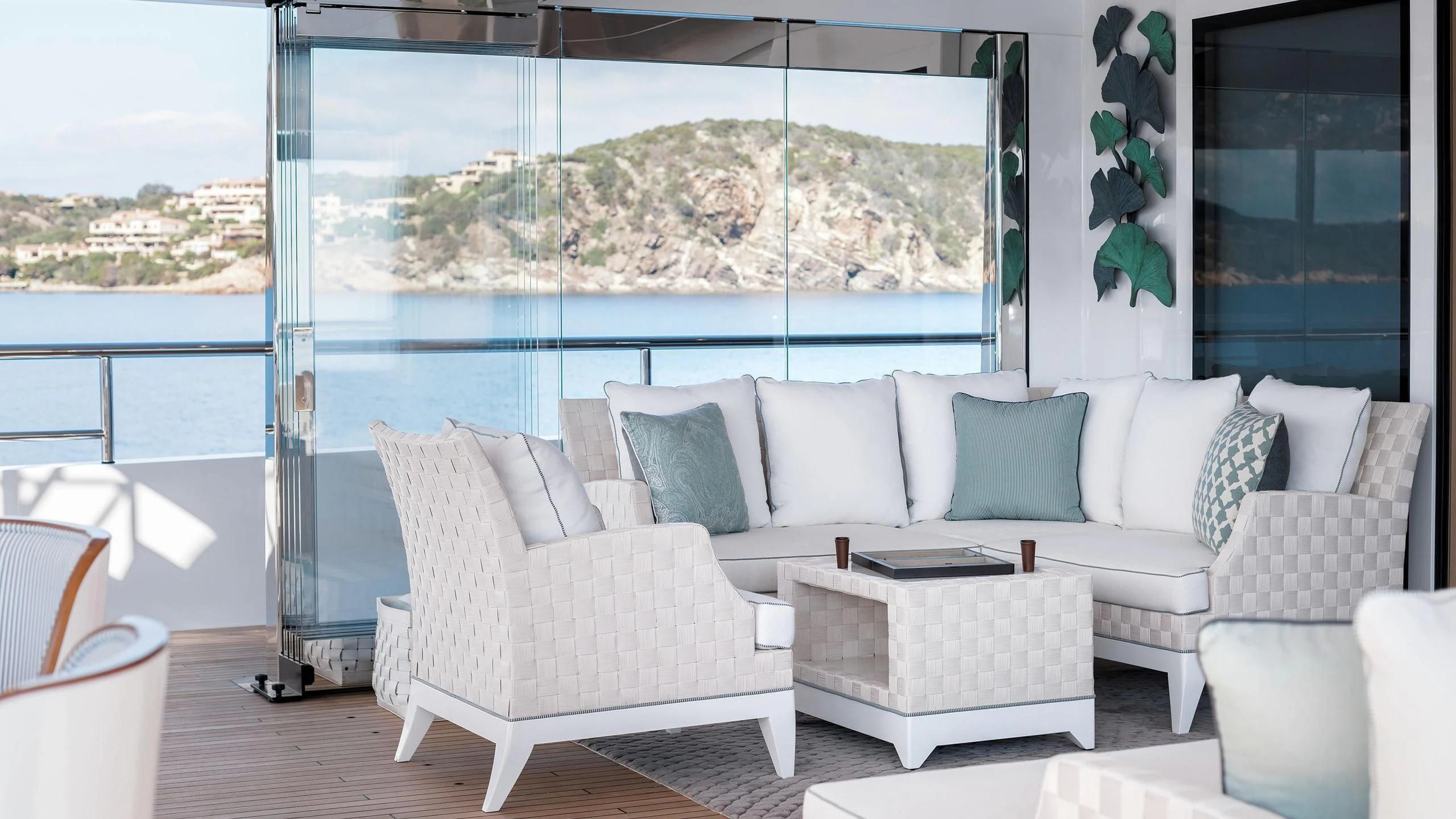 a white couch and a table in a room with a large window aboard JOY Yacht for Sale