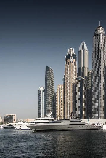 a boat in the water with a city in the background aboard JOY Yacht for Sale