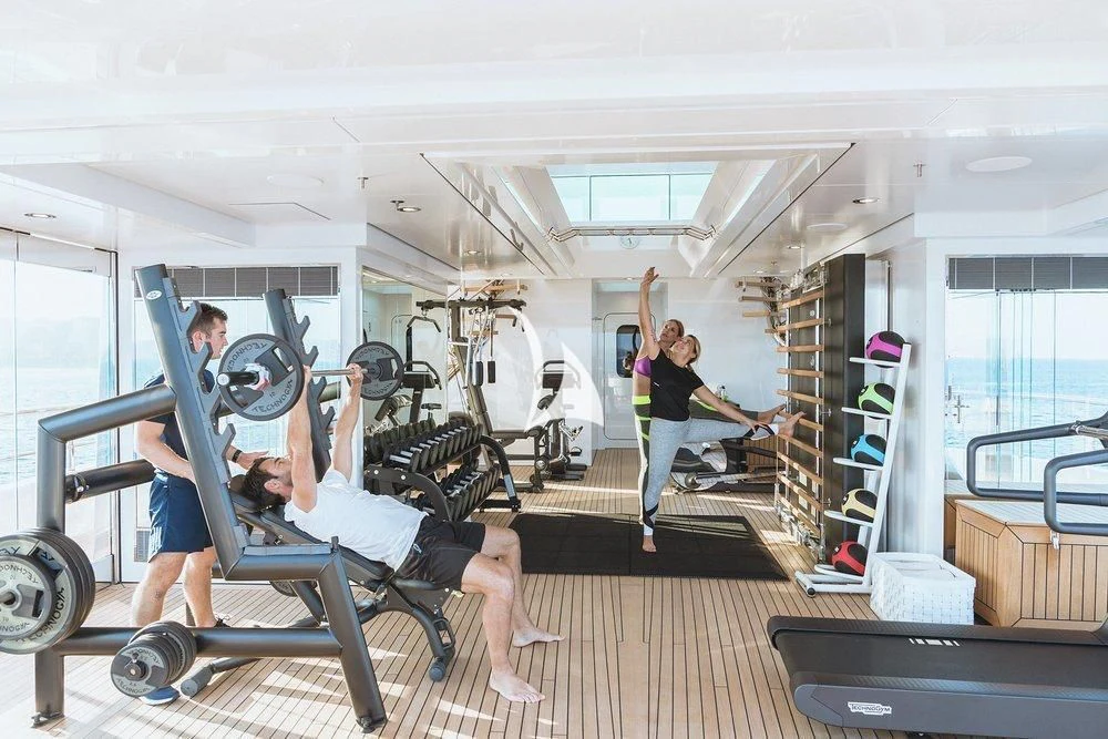 a group of people exercising in a room aboard JOY Yacht for Sale