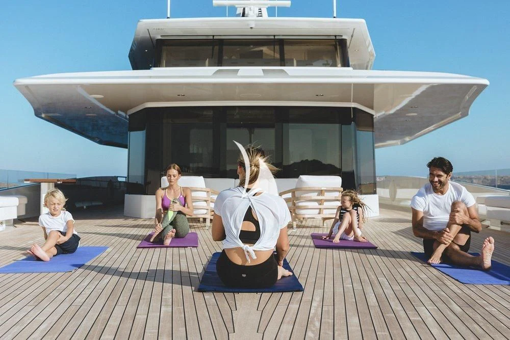a group of people sitting on a deck with a building in the background aboard JOY Yacht for Sale