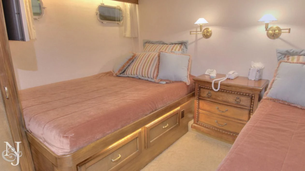 a bedroom with a bed and a dresser aboard WHISKEY DAWN Yacht for Sale