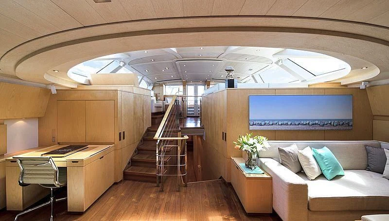 a room with a couch and a table and a staircase aboard GUILLEMOT Yacht for Sale