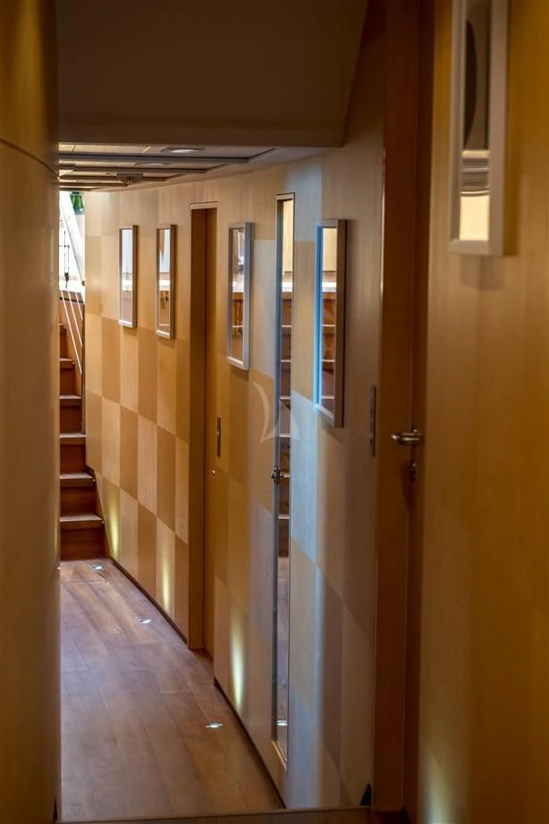 a hallway with a door and a staircase aboard GUILLEMOT Yacht for Sale
