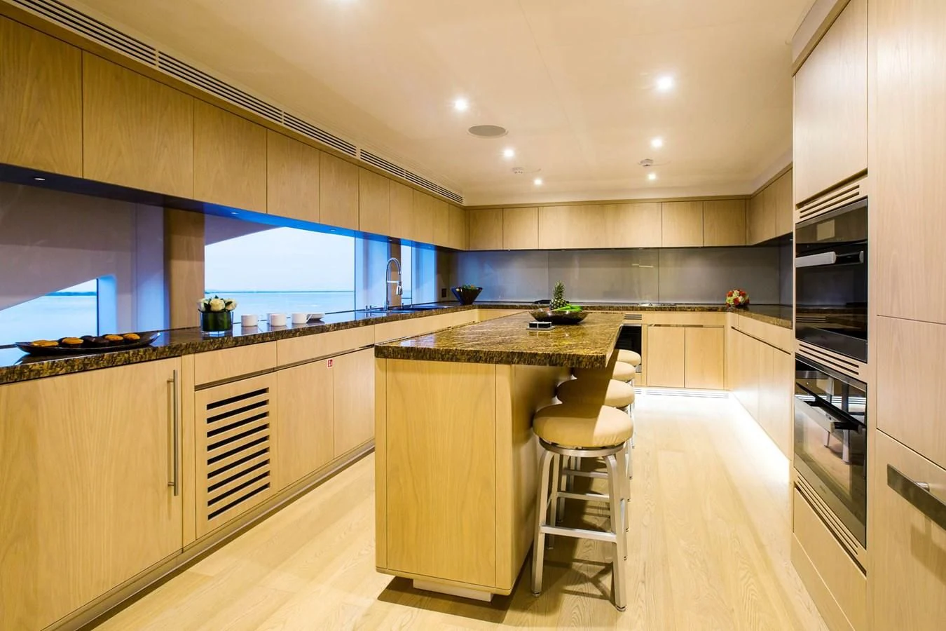 a kitchen with a bar and stools aboard MAJESTY 155 Yacht for Sale