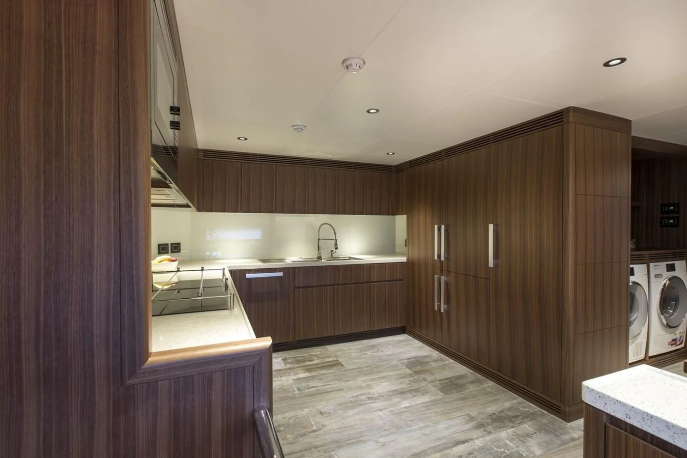 a kitchen with wooden cabinets aboard MAJESTY 155 Yacht for Sale