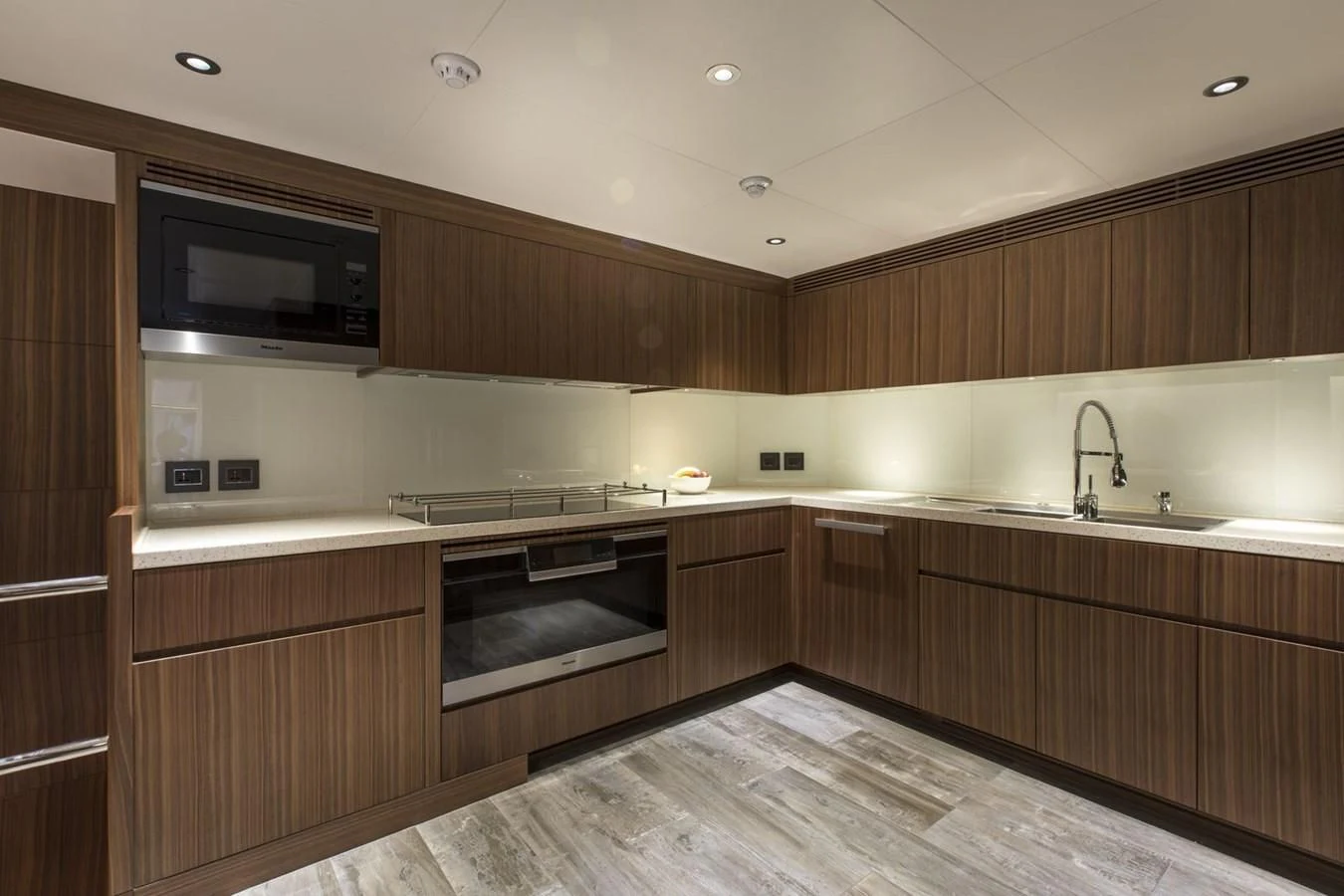a kitchen with wooden cabinets aboard MAJESTY 155 Yacht for Sale