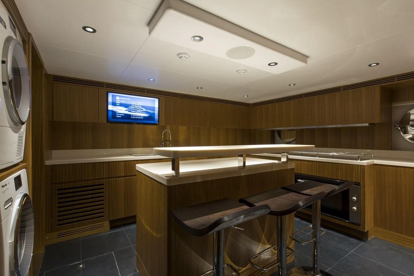 a kitchen with a bar and stools aboard MAJESTY 155 Yacht for Sale