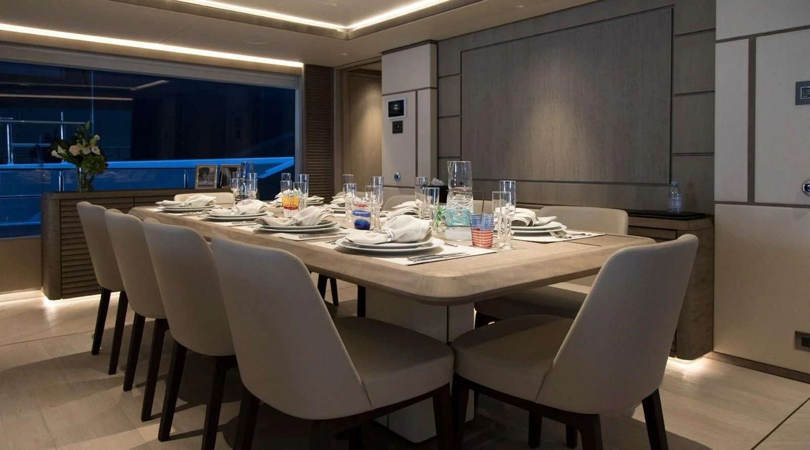 a table with plates and glasses on it aboard MAJESTY 155 Yacht for Sale