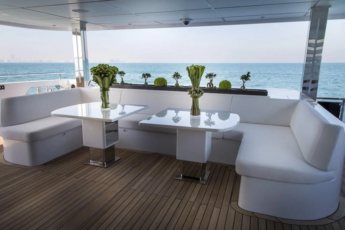 a room with white couches and a table with plants on it aboard MAJESTY 155 Yacht for Sale