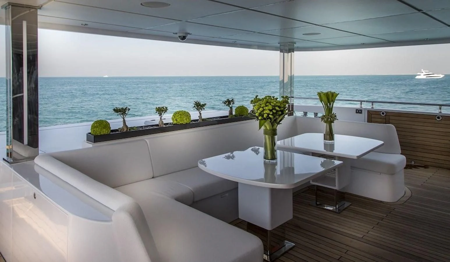 a white couch and table in a room with a large body of water aboard MAJESTY 155 Yacht for Sale