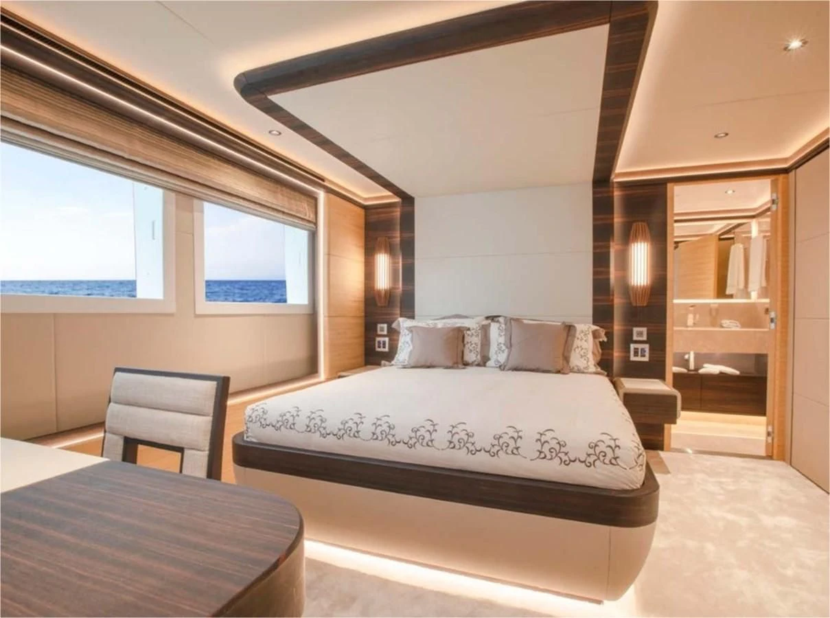 a bedroom with a bed and a table aboard MAJESTY 155 Yacht for Sale