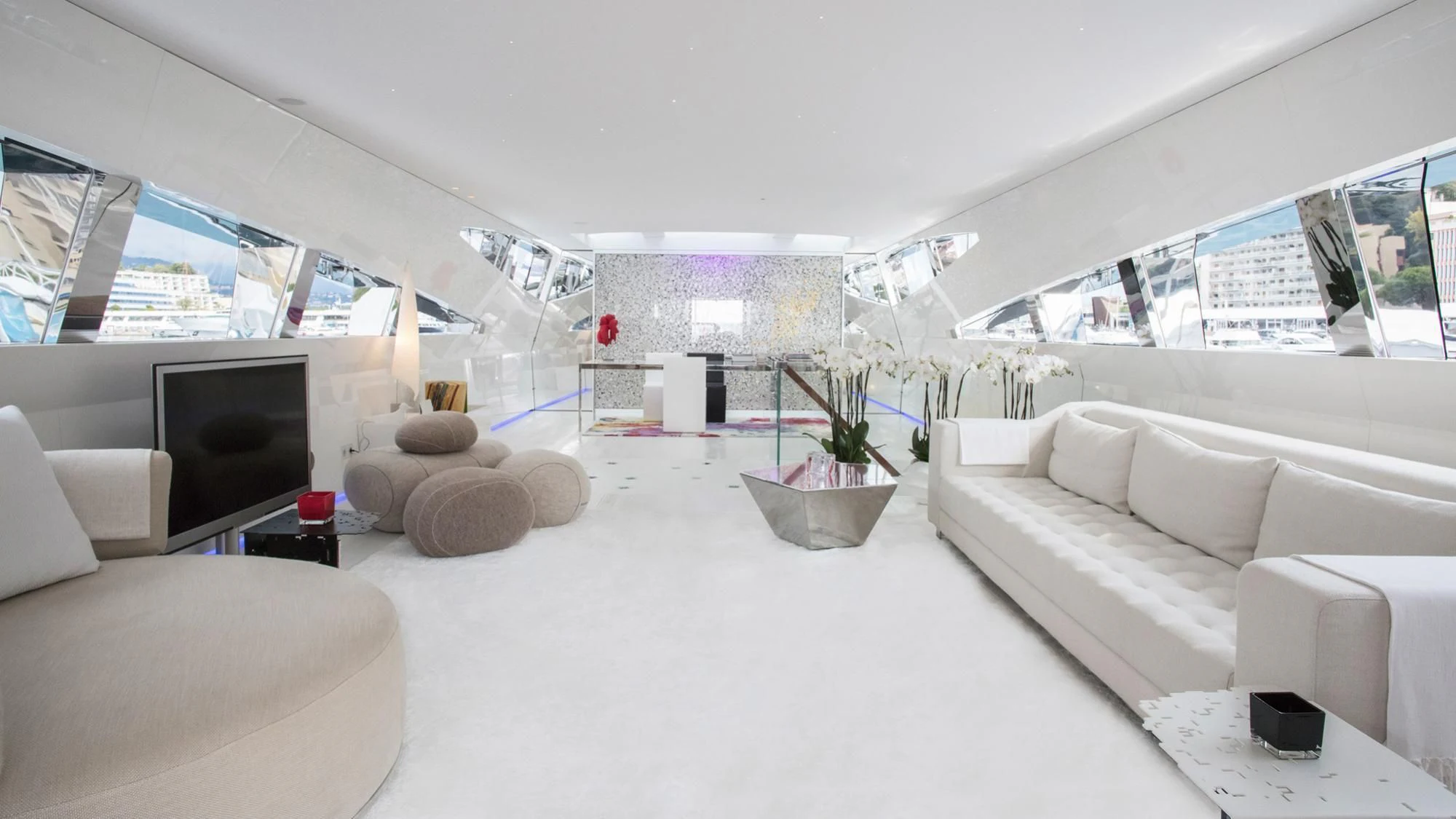 a white living room with a large screen and a large window aboard FLYING DAGGER Yacht for Sale
