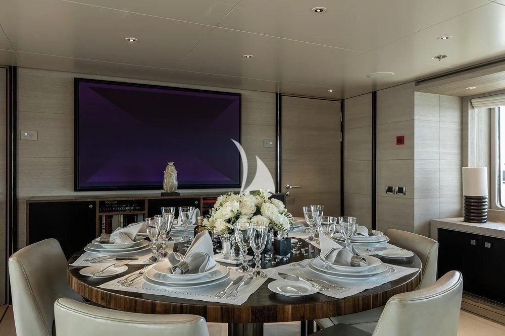 a large table with plates and flowers aboard GRACE (YET) Yacht for Sale