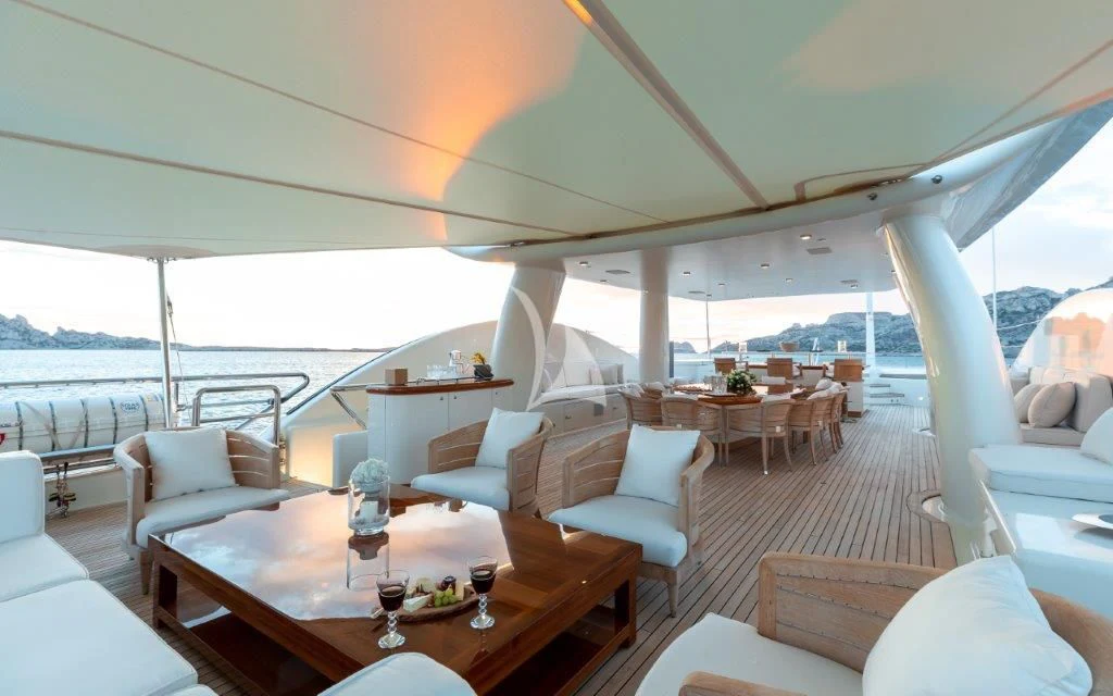 a large room with a table and chairs and a view of the ocean aboard GRACE (YET) Yacht for Sale