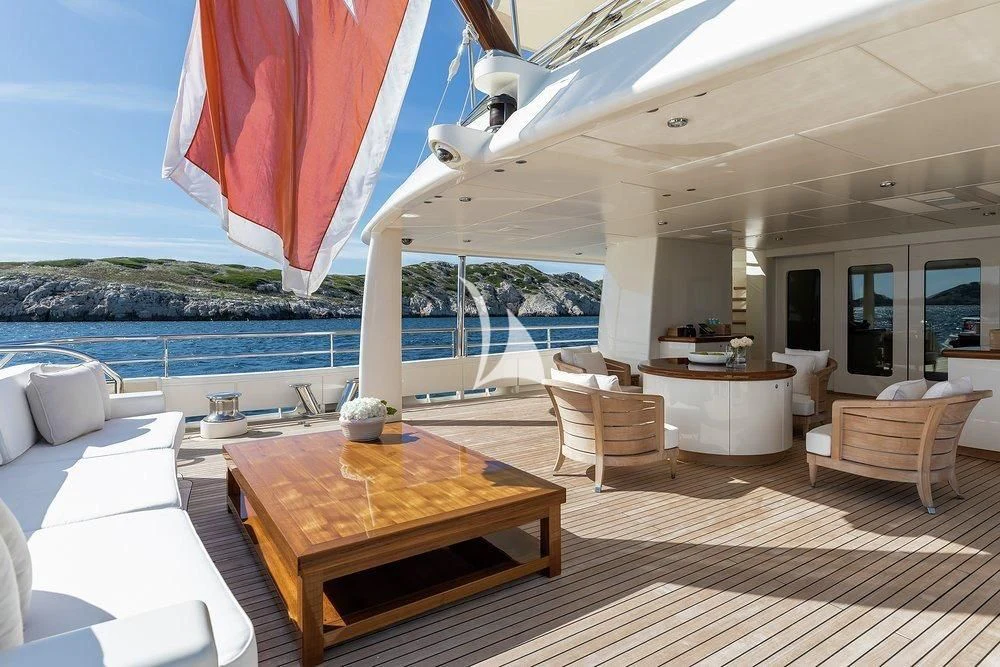 a large open area with a table and chairs and a large pool aboard GRACE (YET) Yacht for Sale
