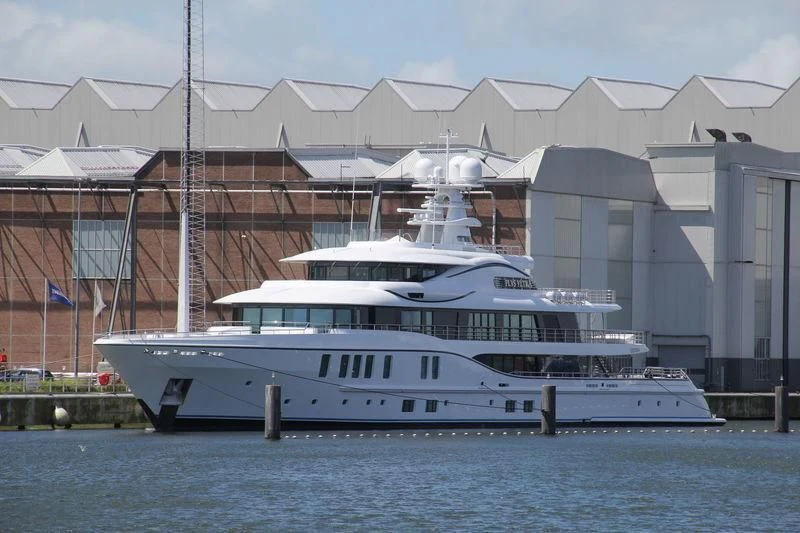 a large white yacht in front of a building aboard PLVS VLTRA Yacht for Sale
