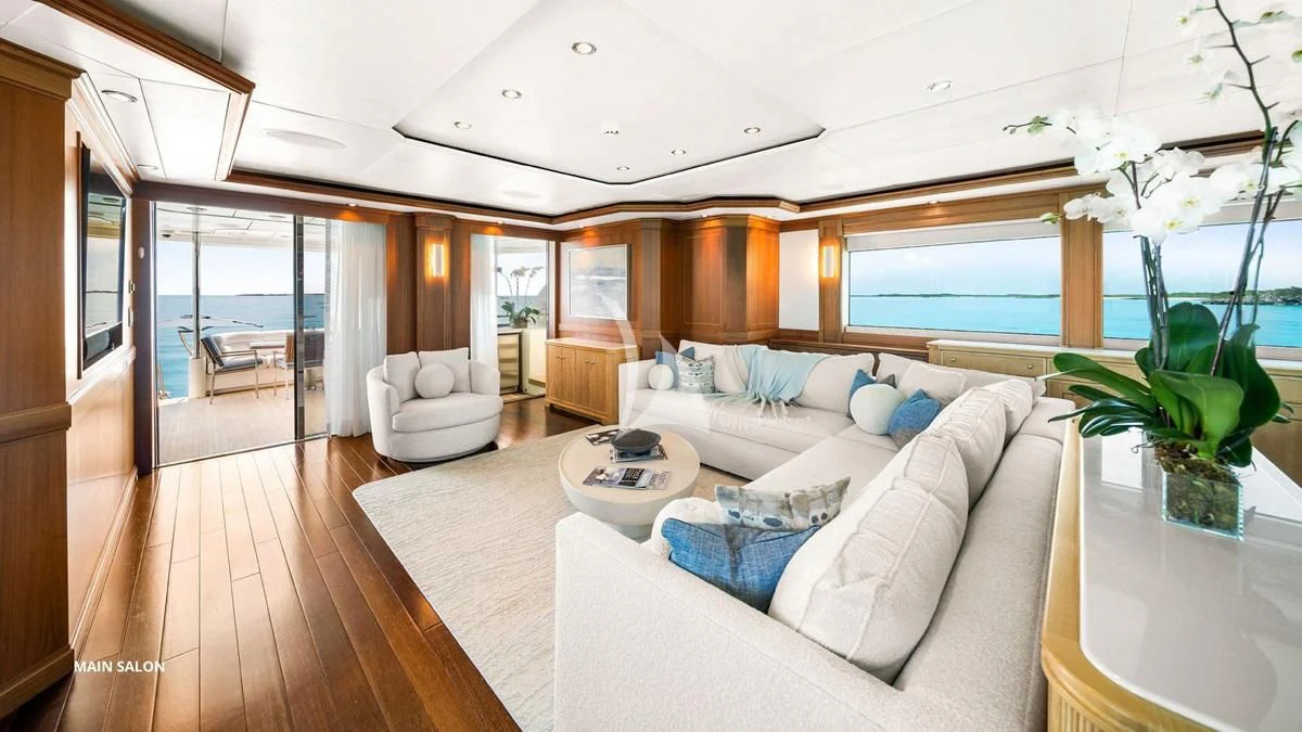 a living room with a large white sofa and a large window aboard BLACK SHEEP Yacht for Sale