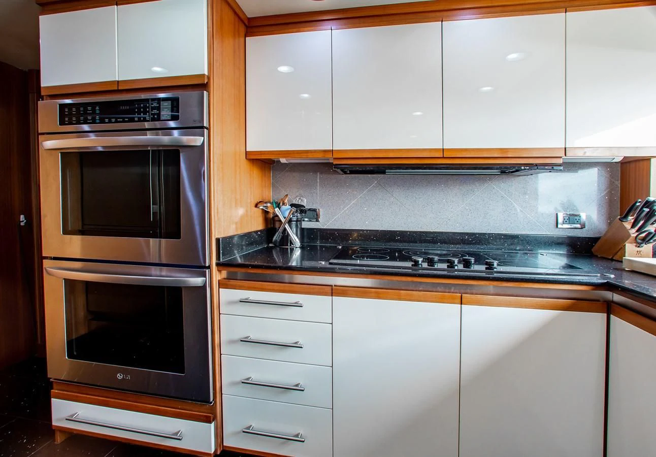 a kitchen with white cabinets aboard BLACK SHEEP Yacht for Sale