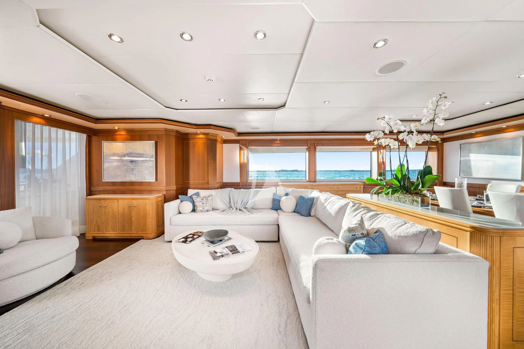 a living room with a large white couch and a large window aboard BLACK SHEEP Yacht for Sale